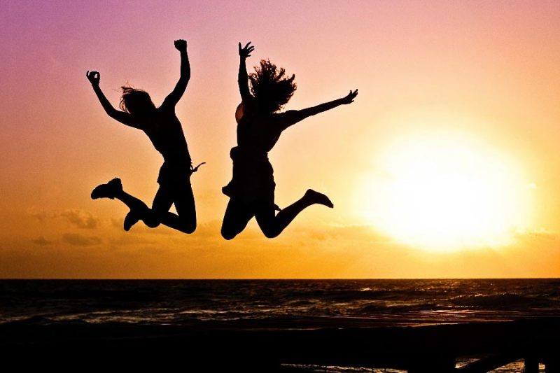 Titelbild Blog Beitrag, Silhouetten von zwei springenden Frauen im Sonnenuntergang